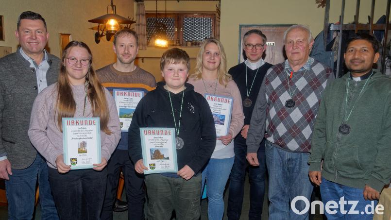 Bürgermeister Rainer Rewitzer, Lisa Enslein, Thomas Enslein, Jonas Enslein, Sarah Schöbel, Pfarrer Karolczak, Alois Hubmann und Pfarrvikar Galli (von links) freuen sich über die tollen Bilder beim Stadtfotografenwettbewerb. Bild: Th. Enslein/exb