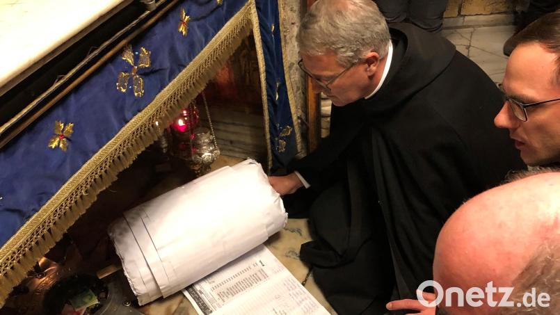 Pater Matthias legt die Rolle mit den mehr als 70 000 Unterschriften, an die Stelle, wo Jesus geboren worden sein soll. Bild: mr
