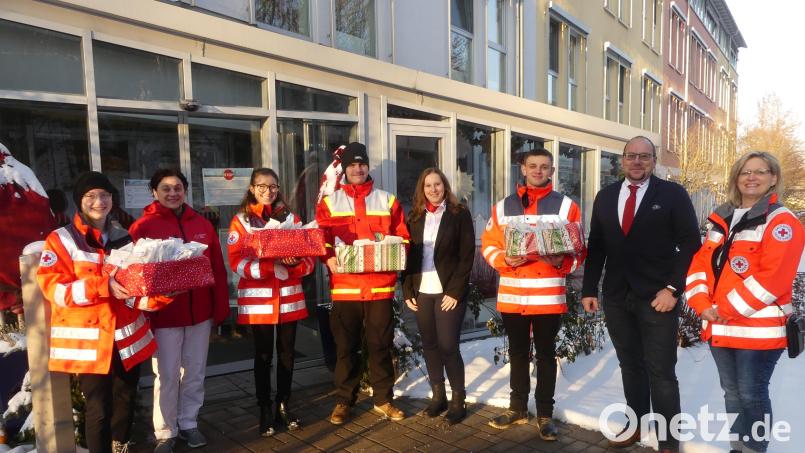 Silke Hecht (rechts) und Mitglieder des Jugend-Rotkreuzes Kirchenthumbach übergeben an Andreas Wöhrl (Zweiter von rechts) und Karin Lanz (Vierte von rechts) 130 Päckchen mit Plätzchen und Lebkuchen. Bild: rn