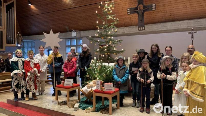 Kinder führen in der Hohenkemnather Kirche das Rollenspiel „Geschenke fürs Christkind“ auf. Darüber freut sich auch Ruhestandpfarrer Joseph Madathiparamil (hinten rechts). Bild: Hermann Schmidt