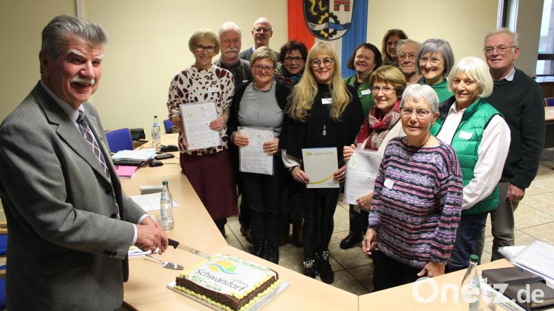 Im Anschluss an die Sitzung des Seniorenbeirats waren die Mitglieder zu Glühwein und einem Jubiläums-Kuchen eingeladen, der von stellvertretendem Landrat Jakob Scharf (links) angeschnitten wurde. Bild: Hans Prechtl/exb