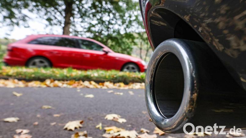 Hinter dem Auspuff eines Pkw fährt ein Auto vorbei. Bild: Oliver Berg/dpa/Symbolbildarchiv