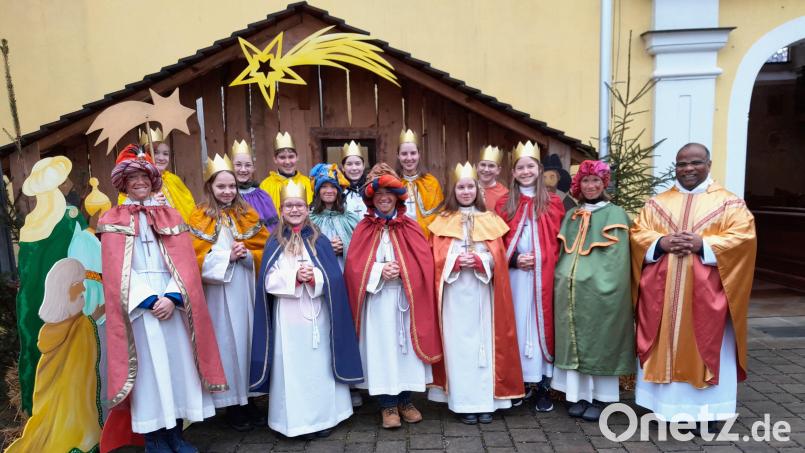 Die Sternsinger vor der Krippe bei der Pfarrkirche St. Walburga in Lintach mit Pfarrer Moses Gudapati. Bild: jow