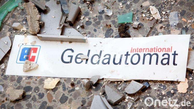 Splitter und ein Schild mit der Aufschrift „Geldautomat“ liegen auf dem Fußboden. Bild: Patrick Pleul/zb/dpa