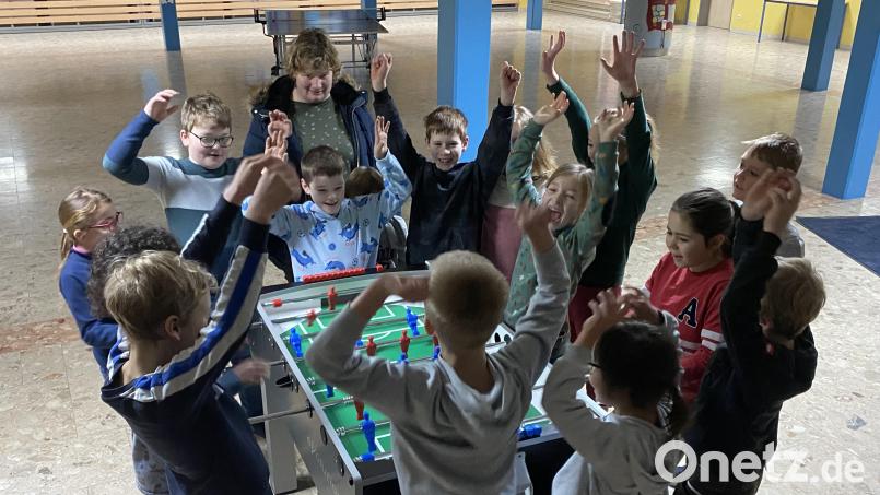 Die Kinder freuen sich über den neuen Kicker. Corinna Schönberger (hinten Mitte), Mitglied des Elternbeirats, hat das Gerät beschafft. Bild: Josef Glas