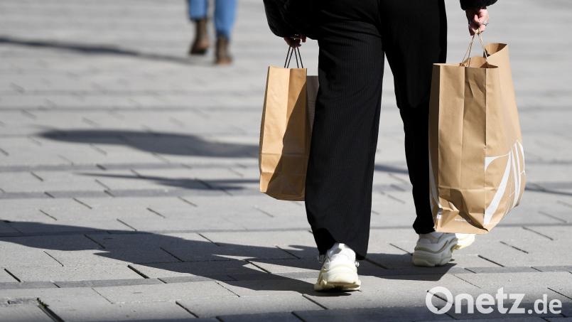 Eine Frau schlendert mit Einkaufstüten von einem Modegeschäft durch die Stadt. Symbolbild: Angelika Warmuth/dpa