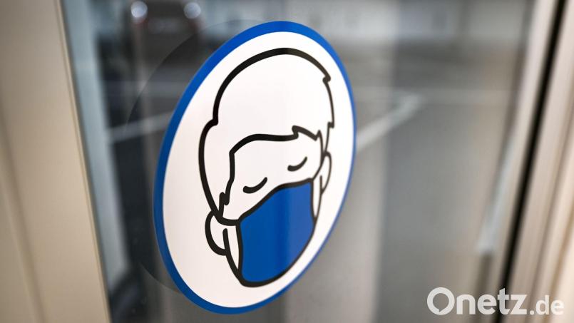 Ein Aufkleber an einer Glastür weist auf das Tragen einer Maske hin. Symbolbild: Felix Kästle/dpa