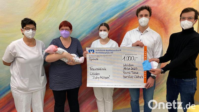 Die kleine Lilli und ihre Mama Michaela sind die ersten, die eine der neuen Mützchen erhalten haben, bei deren Anschaffung der Round Table 49 unterstützt. Ines Erhardt und Annette Lechler bedankten sich für die Spende des Clubs um Präsident Marc Lohse und Markus Rechl. Bild: Kliniken Nordoberpfalz, Michael Reindl/exb