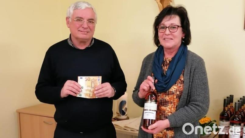 Vorsitzende Monika Bösl überreichte Pfarrer Eugen Wismeth eine Spenden für Pater Johannes Strauß in Bolivien. Bild: Elisabeth Bauer/exb