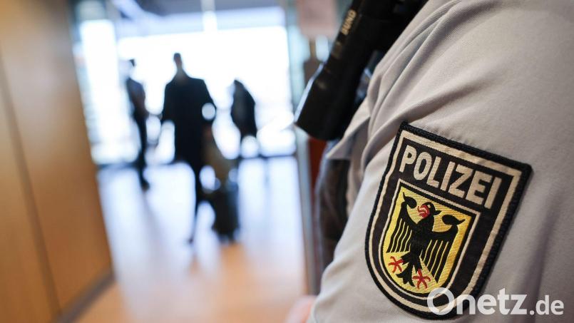 Ein Beamter der Bundespolizei kontrolliert Reisende am Flughafen. Bild: Christian Charisius/dpa/Symbolbild