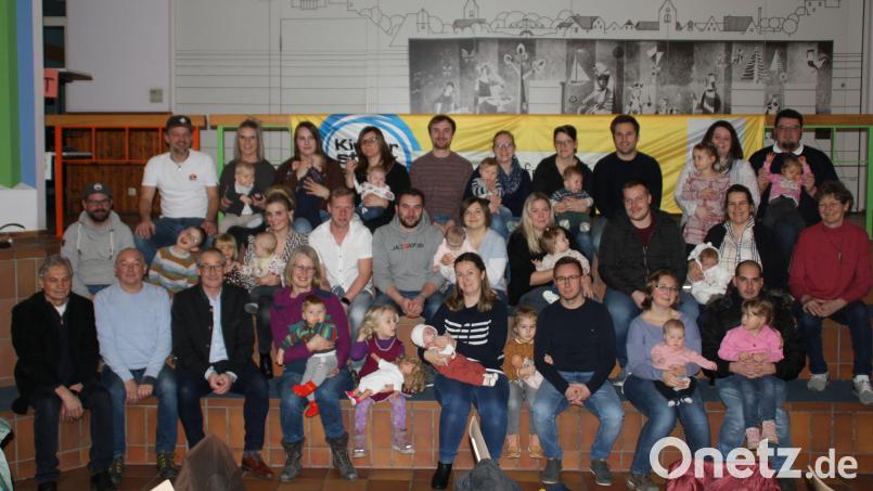 Die Baby und ihre Eltern nehmen in der Aula der Grundschule das Babybegrüßungsgeld der Marktgemeinde aus den Händen von Bürgermeister Erwin Geitner in Empfang. Bild: sam