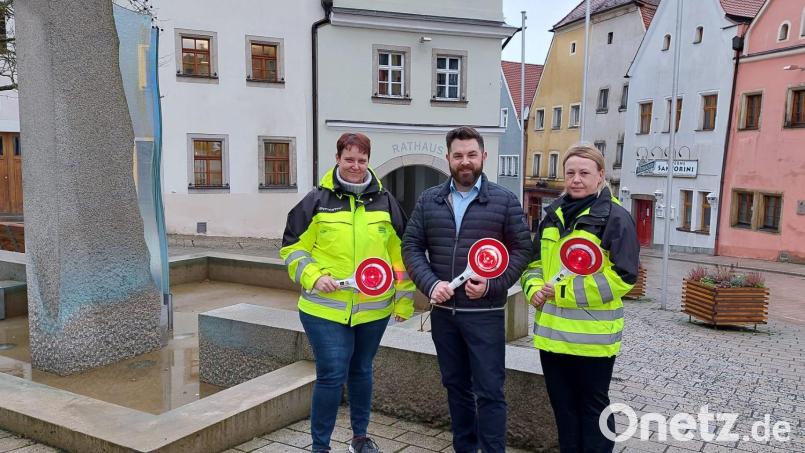 Die Schulweghelferinnen Andrea Rudolph (links) und Valentina Jäger (rechts) mit Bürgermeister Sebastian Dippold. Die neuen, beleuchteten Winkerkellen, die von der Stadt angeschafft wurden, sollen Schulweghelfern und Schülern mehr Sicherheit geben. Bild: Corinna Hagn/exb