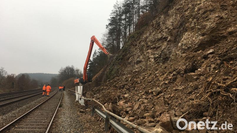 Ein Langstielbagger trägt loses Gestein ab. Der Hang wird nach dem Felssturz neu profiliert. Bild: ihl