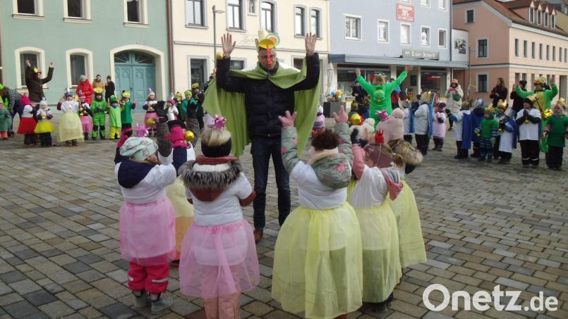 Nachdem ihm die Krawatte abgeschnitten worden ist, verzaubern zwei kleine Feen Bürgermeister Hermann Falk in einen Frosch. So kostümiert tanzt er mit den Kindern. Bild: u