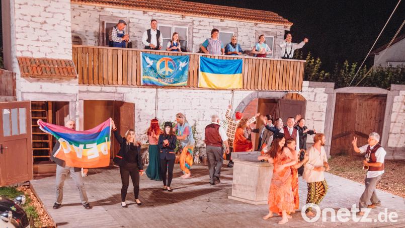 Hippies bevölkern die Bärnauer Freilichtbühne. Am letzten Wochenende im Juli war die Premiere des Stücks &quot;Ein Sommer voller Träume&quot;. Die Dorfbewohner und die Hippies singen gemeinsam ein Lied. Dabei hissen sie eine Fahne mit dem Friedenszeichen und die Flagge der Ukraine. Bild: sfo