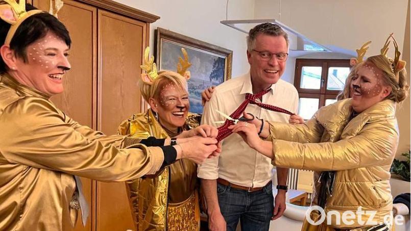 Das „Narrhalla-Hirschi-Trio“ mit (von links) Präsidentin Regina Merkl, Hofdame Ramona Frauendorfer und Prinzessin Michaela I. macht am Unsinnigen Donnerstag Bürgermeister Hermann Falk die Aufwartung in seinem Amtszimmer. Prinzessin Michaela I. schreitet zur Tat, zückt die Schere und schneidet dem Rathaus-Chef den Schlips ab. Bild: u