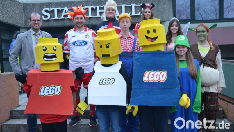 Die drei „Lego-Männer“ holen sich den Sieg beim Realschulfasching. Die drei Burschen haben die Kostümierung in Eigenregie hergestellt. Doch auch Bob der Baumeister oder die Minnie Maus erregen Aufsehen. Realschuldirektor Kilian Graber (links) gratuliert den Gewinnern. Bild: dob