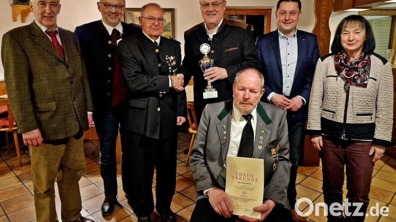 Lothar Höher (Dritter von rechts) übergibt einen Pokal an Schützenmeister Franz Fuhrmann (3. V.li). Sitzend präsentiert Peter Haring, eine Urkunde für 60 Jahre im Schützenbund.. Bild: R. Kreuzer