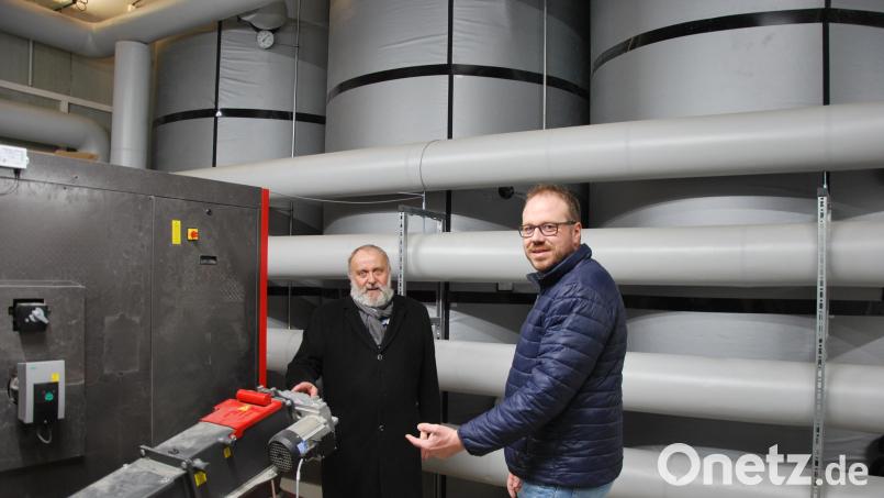 Ammerthals Bürgermeister Anton Peter und Bauherr Michael Rädle (von links) begutachten die Hackschnitzelheizung zur Nahwärmeerzeugung in Illschwang, wie sie auch in Ammerthal errichtet werden soll. Bild: gsp