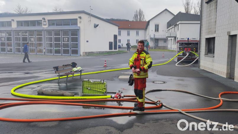 Nach der Übung begutachtete Atemschutzträger Bastian Kaiser von der Feuerwehr Erbendorf die Löschwasserversorgung außerhalb des Brandhauses (rechts im Bild) der staatlichen Feuerwehrschule Würzburg. Bild: fks