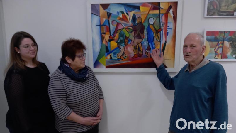 Den Frauen von der Kunst AG, Sieglinde Konhäuser und Carina Kö.rner (links) erläutert Walter Heiter sein Bild &quot;Arbeit im All&quot;. Bild: hka