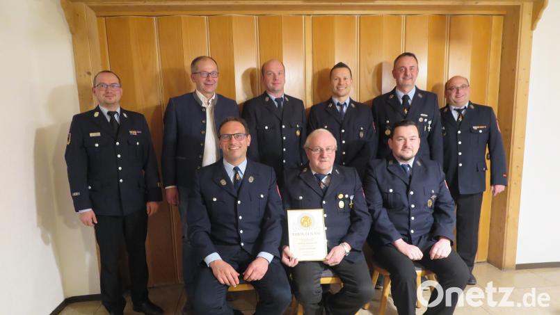 Kreisbrandmeister Florian Braunreuther, Bürgermeister Roman Schäffler, Sebastian Busch, Florian Trummer, Thomas Reger, Markus Nickl (stehend von links), Thomas Reger (links sitzend) und Stefan Pflanzl (rechts sitzend) gratulierten Erich Busch zu seinem 50. Jubiläum. Bild: jzk