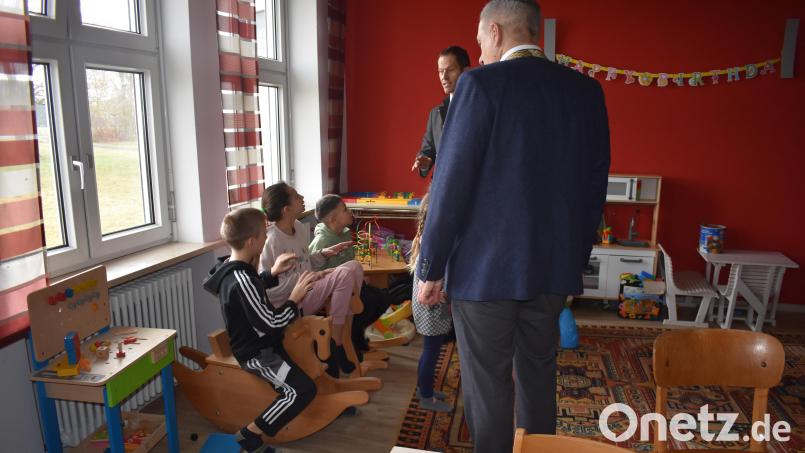 Kinder beschäftigen sich im Spielzimmer in der Notunterkunft in Fockenfeld. Bei einem Termin besichtigen Landrat Roland Grillmeier (vorne, rechts) und Bundestagsabgeordneter Albert Ruprecht die Räumlichkeiten. Bild: lue