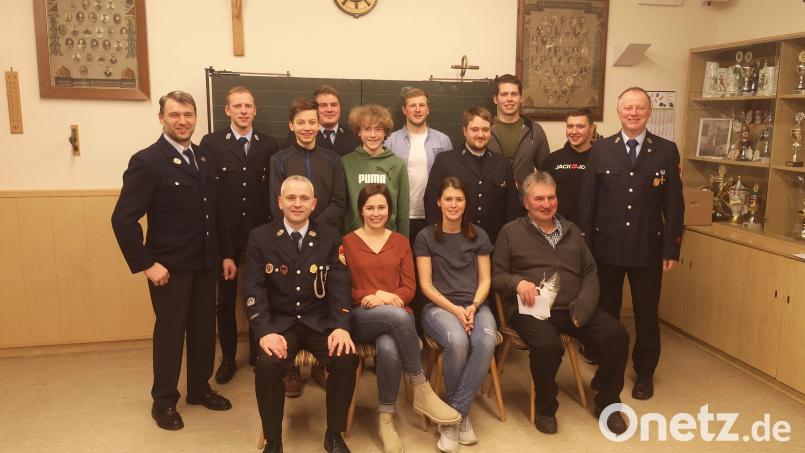 Die geehrten, beförderten und neu aufgenommenen Mitglieder der Feuerwehr Münchenreuth zusammen mit Kommandant Klaus Grötsch (sitzend, links) und Vorsitzendem Berthold Ernstberger (stehend, rechts). Rechts sitzend Josef Eckert, der nach 40 Jahren aus dem aktiven Dienst verabschiedet wurde. Bild: Bernhard Ernstberger/exb