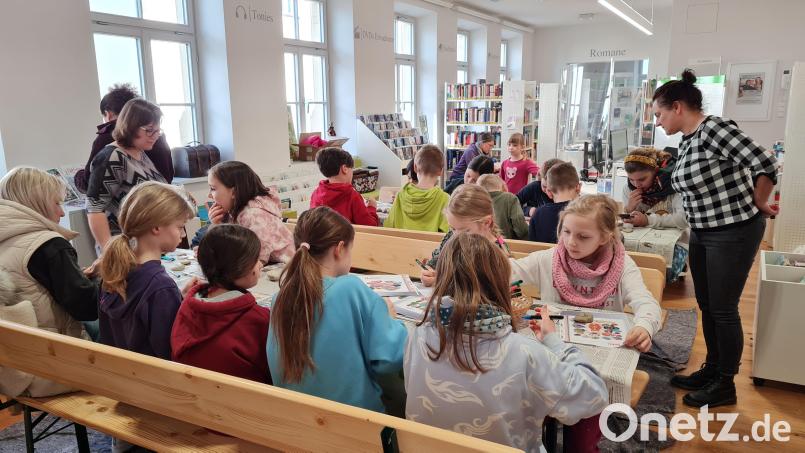 Monika Landgraf (stehend links) und Andrea Hausner (stehend rechts) haben ebenso viel Spaß bei der Malaktion wie die Kinder. Bild: Petra Danzer/exb