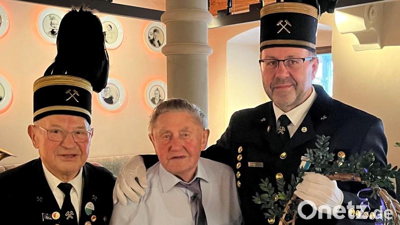 Bergknappenvereins-Vorsitzender Armin Kraus (rechts) und sein Stellvertreter Georg Rubenbauer (links) gratulierten Josef Sippl mit einem Geschenkkorb zum 95. Geburtstag. Bild: ksa