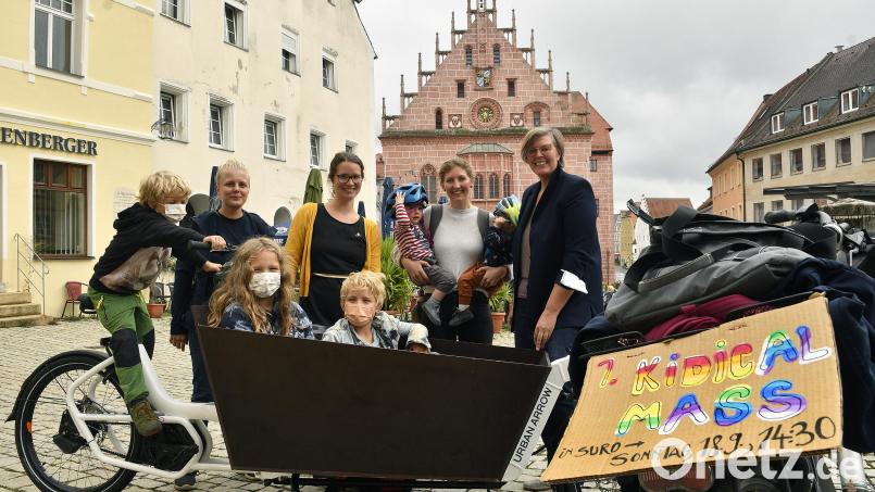 Mehr kinderfreundlicher Fahrradverkehr ist nur eines von vielen Zielen der tat.ort-Mitglieder Margarete Lösl, Kathrin Altmann, Miriam Herbst und Kerstin Paul (von links, die vier Frauen hinten). Mit dem Plakat machen sie Werbung für die Fahrrad-Demo „Kidical Mass“ am Samstag. Bild: Petra Hartl