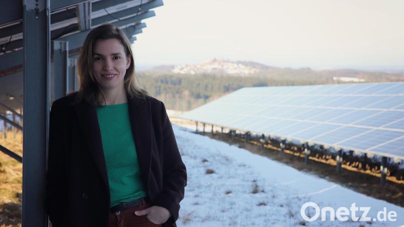 Laura Weber auf dem Gelände einer Photovoltaik-Anlage. Im Hintergrund ist der Ort Leuchtenberg zu erkennen (Kreis Neustadt/Waldnaab). Die Oberpfälzerin setzt sich unter anderem für Erneuerbare Energien und die Chancengleichheit von Frauen ein. Bild: Sara Neidhardt