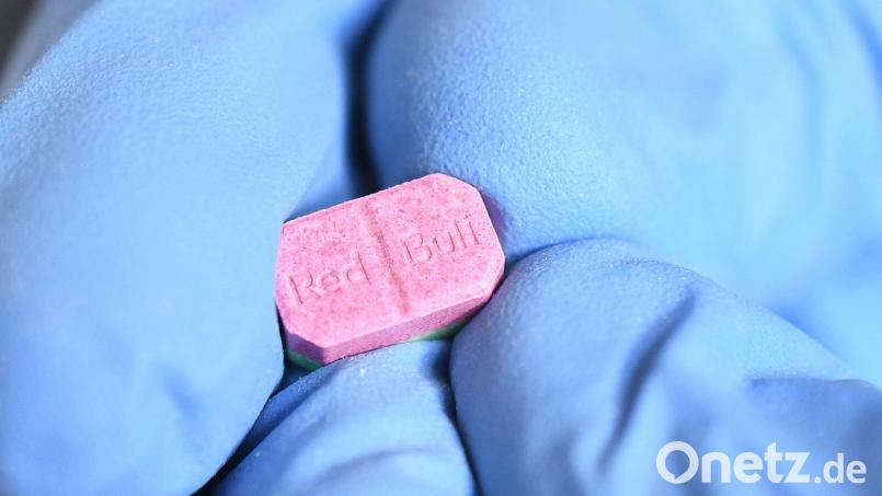 Ein Zollmitarbeiter zeigt eine sichergestellte Ecstasy-Pille. Die Droge soll ein heute 24-Jähriger an zwei 14- und 15-jährige Brüder verschenkt haben. Das Schwandorfer Schöffengericht schickte den Mann ins Gefängnis. Symbolbild: Henning Kaiser/dpa