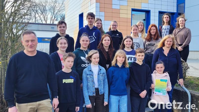 Die Klasse 8a des Gymnasiums hat einen Geldpreis gewonnen. Schulleiter Christian Schwab (links) gratulierte gemeinsam mit der betreuenden Lehrkraft Nadine Kilgert-Bartonek (rechts) zu diesem Erfolg. Bild: A. Fröhlich/exb
