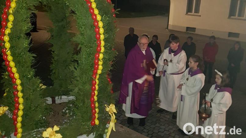 Pfarrer Gottfried Rottner segnet die Osterkrone, die der Gartenbau- und Ortsverschönerungsverein Saltendorf geschmückt hat. Bild: Konrad Kiener/exb