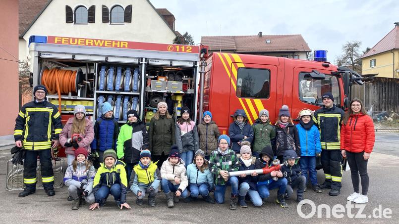 Die Jugendwarte Dominik Schießlbauer (links) und Andreas Stepper (rechts) verstanden es, die Kinder mit ihrer Lehrerin Laura Aigner (rechts) für die Feuerwehr zu begeistern. Bild: Ortrud Sperl/exb