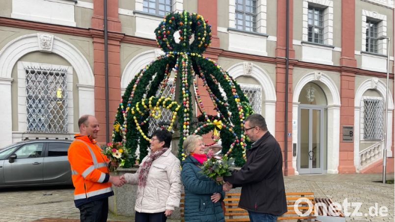Marco Harrer, stellv. Bauhofleiter, Meta Fichtner, Gabi Fröhlich und Geschäftsleiter Peter Forster (von links) beim Überreichen der Dankes-Blumen vor dem Osterbrunnen am Stadtplatz in Neustadt/WN. Bild: Corinna Hagn/exb