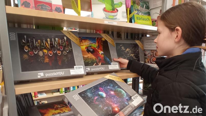 Puzzlefan Sarah durchstöbert das neue Regal in der Pirker Bücherei. Bild: kki