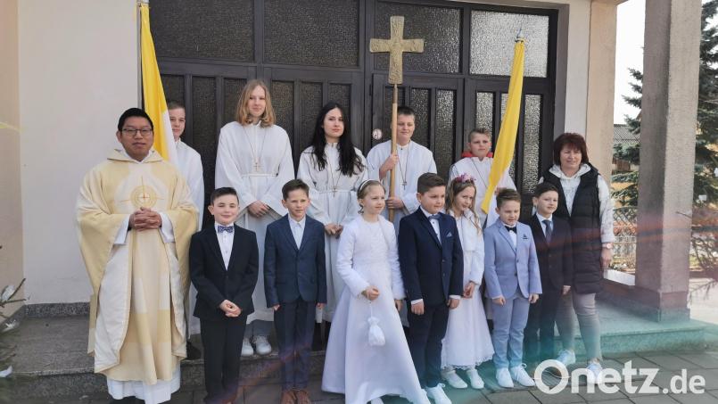 Nach dem Gottesdienst präsentieren sich die Kinder mit den Ministranten mit Pater Samuel Patton (links ) und Marion Eschenweck (rechts )vor dem Pfarrheim. Bild: hzi