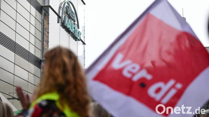 Beschäftigte protestieren mit einer Fahne der Gewerkschaft Verdi vor einem Galeria Karstadt Kaufhof. Bild: Bernd Weißbrod/dpa/Archivbild