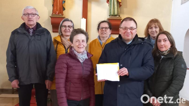 Über 500 Euro kamen bei der Palmbuschen-Aktion zusammen. Die Spende übergab KAB-Vorsitzende Claudia Porst an Pfarrer Markus Bruckner (Dritte und Fünfter von links). Bild: mez