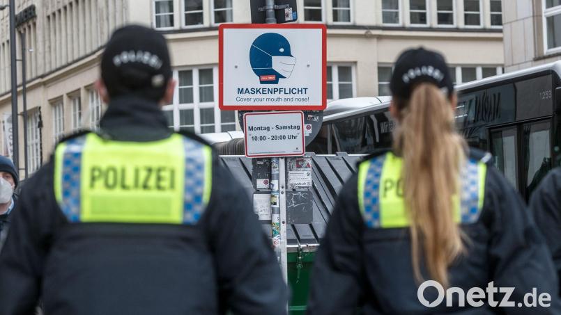 Polizisten patrouillieren in einer Stadt, um die Maskenpflicht zu kontrollieren. Symbolbild: Markus Scholz/dpa/
