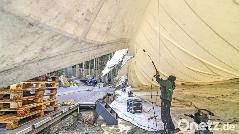 Bevor die Handwerker das Dach hochziehen, säubern sie es mit Hochdruckreiniger auf der Unterseite. Bild: Florian Miedl/fph