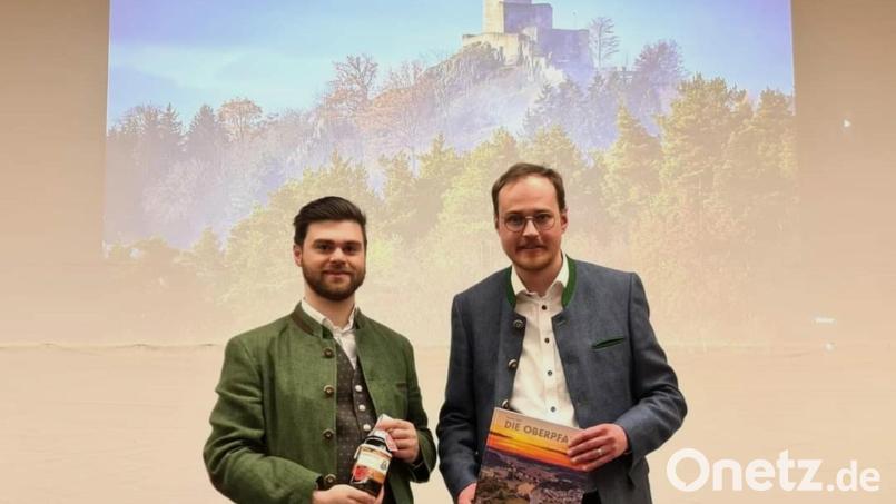 CSU-Ortsvorsitzender Tobias Ehrenfried bedankt sich bei Simon Süß für den kurzweiligen Vortrag mit einer Oberviechtacher Spezialität. Bild: CSU-Ortsverband Oberviechtach/exb