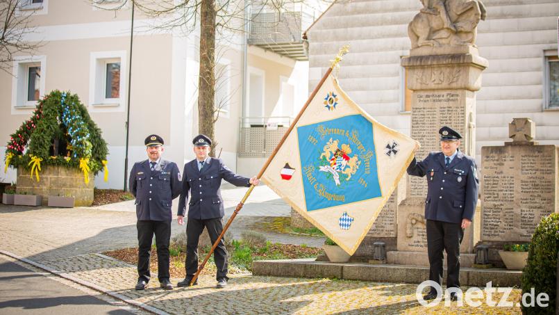 Vorsitzender Michael Pühl, Schriftführer Rainer Wagner und Dritter Vorsitzender Martin Bär (von links) mit der restaurierten Fahne vor dem Kriegerdenkmal auf dem Dorfplatz in Kastl. Bild: Hans Walter/exb