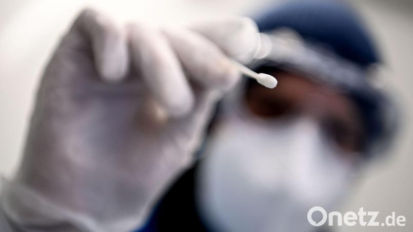 Ein Arzt nimmt mit einem Teststäbchen eine Probe für einen PCR-Test: Das Gesundheitsamt Amberg fordert ehemals PCR-positiv Getestete auf, an einer Befragung zu Long-Covid und Post-Vac-Syndrom teilzunehmen. Archivbild: Britta Pedersen/dpa