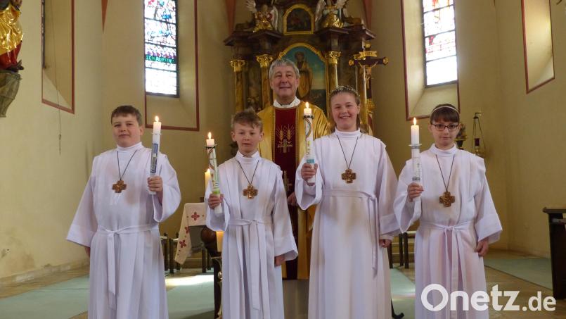 Kristian Basan, Dominik und Marie Bodensteiner sowie Viktoria Messer (von links) mit Pfarrer Adam Nieciecki vor dem Hochaltar in der Döllnitzer St.-Jakobus-Kirche. Bild: sl