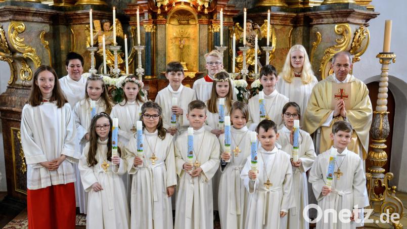 Zwölf junge Christen feiern in Ehenfeld Erstkommunion. Pfarrer Hofmann (rechts) und Gemeindereferentin Schlosser (hinten links) haben sie auf diesen besonderen Tag vorbereitet. Bild: fdl