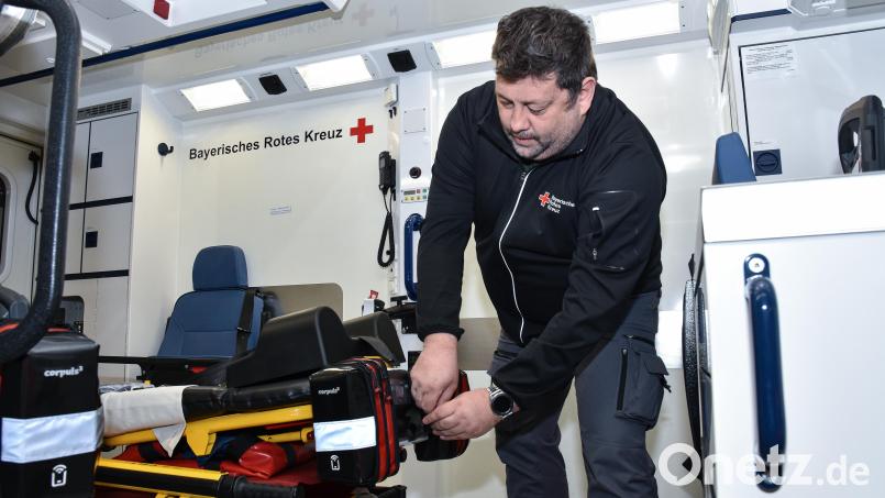 Stellvertretender Rettungsdienstleiter Florian Himmelhuber befestigt das Gerät an der Patiententrage im Rettungswagen. Bild: Stephan Huber