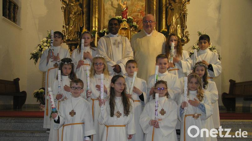 Pfarrer Julius Johnrose (hinten links) und Diakon Harald Schraml (hinten rechts) begleiteten die Erstkommunionkinder auf ihrem Weg zum Tisch des Herrn. Bild: öt